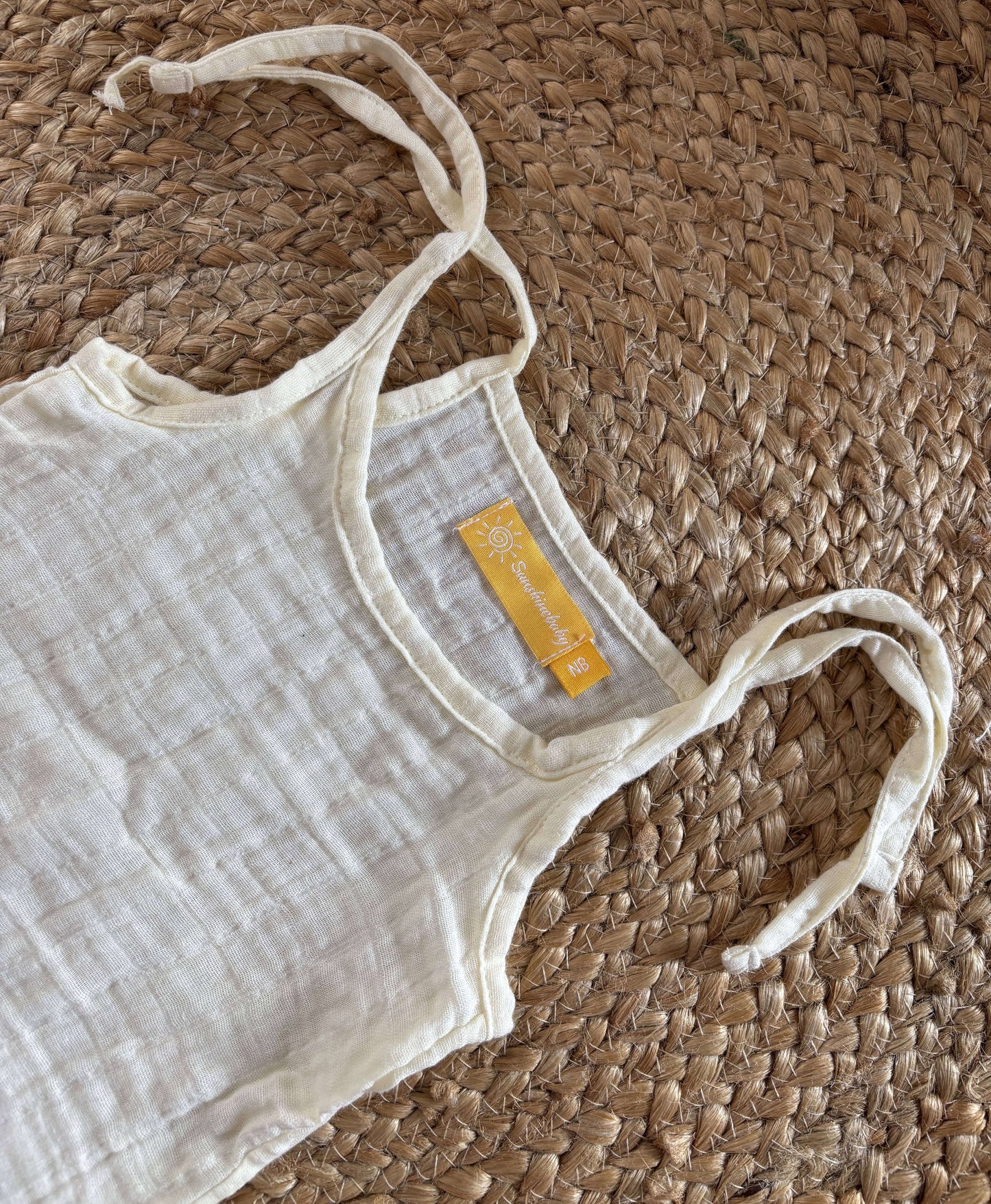 Side view of newborn unisex easy wear top highlighting its relaxed fit and lightweight muslin cotton material.